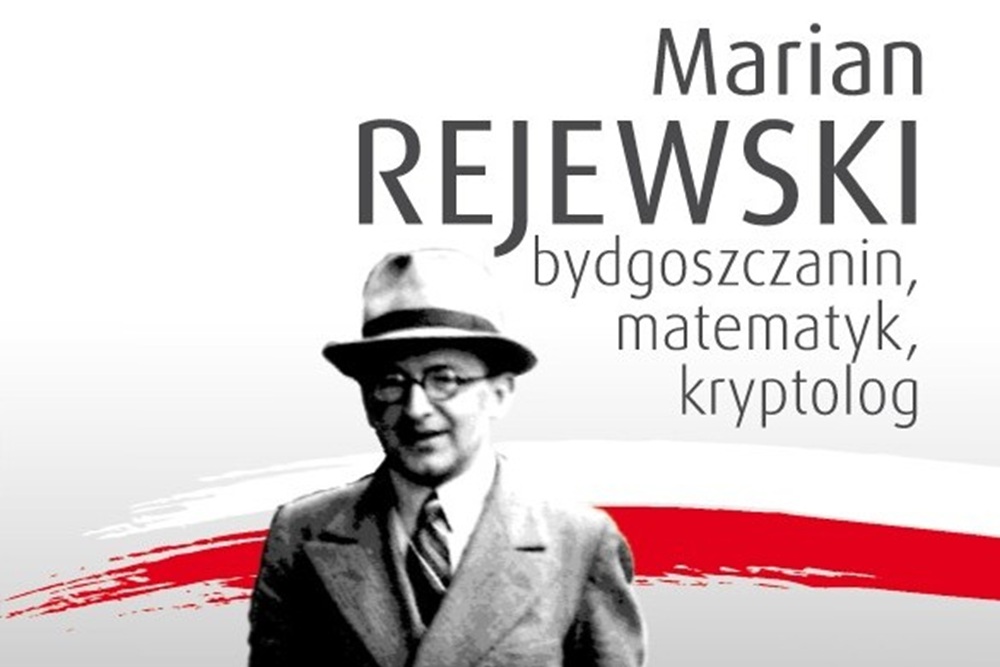 Portret mężczyzny w kapeluszu, za nim szarfa biało-czerwona. Napis Marian Rejewski - Bydgoszczanin, matematyk, kryptolog.